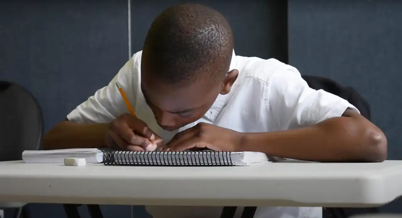 A Hope Academy student writing in a notebook